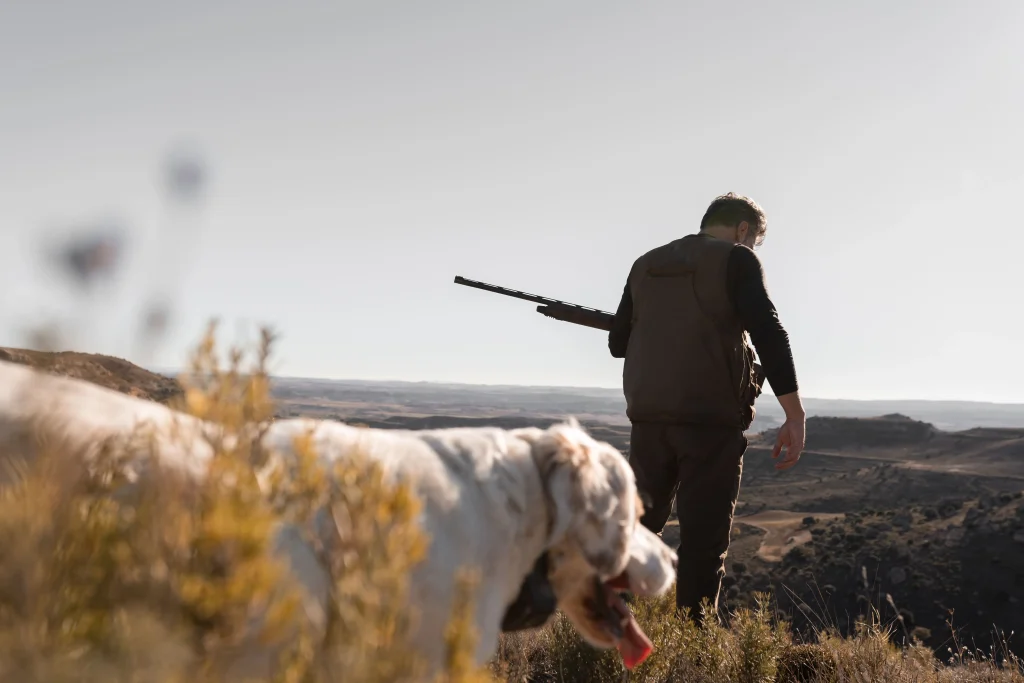 Jägare med sin hund som är ute och jagar